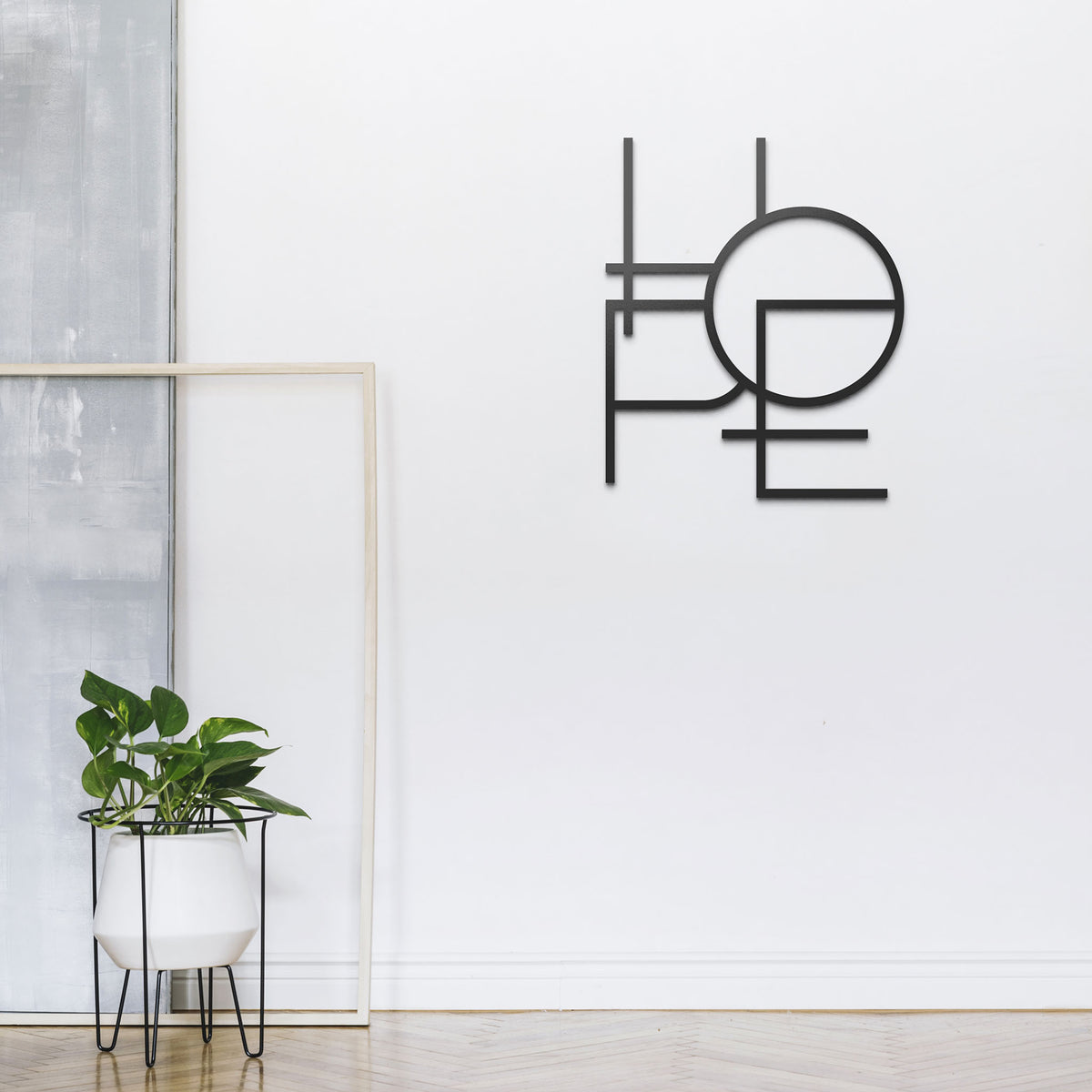 Mesi Hope Wanddeko in hellem Flur mit einer gruenen Pflanze in weißem Topf